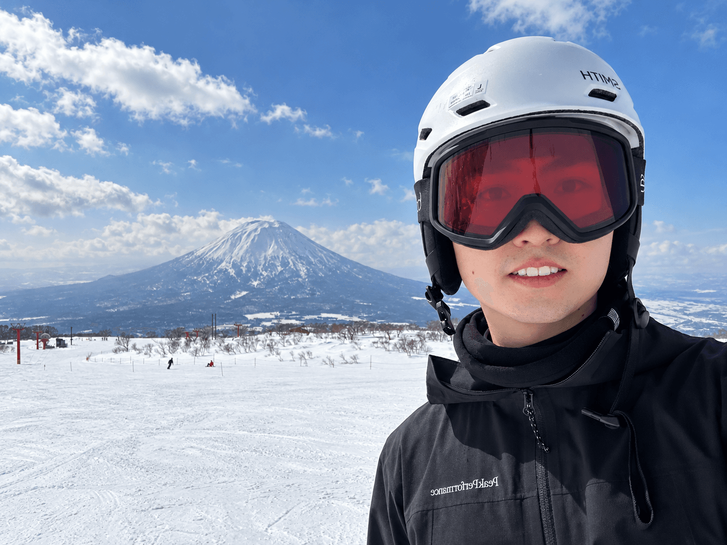 Chao Cheng skiing, with a snow-covered mountain behind him